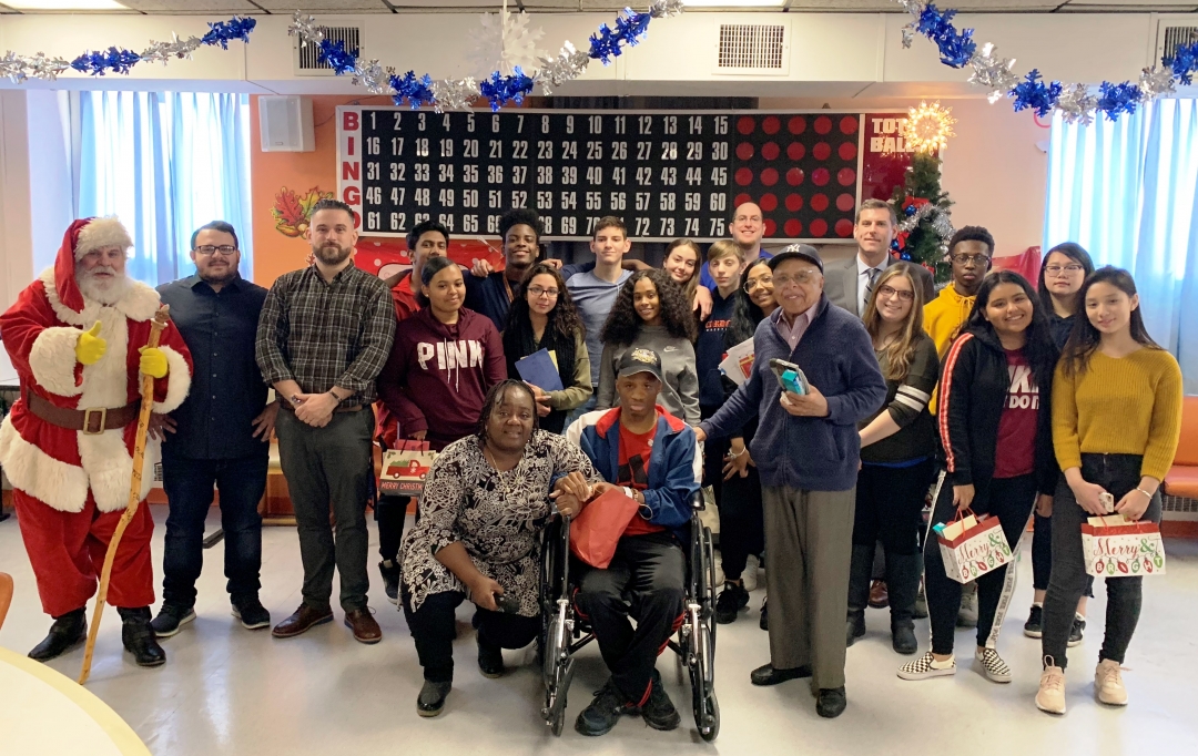 Assemblyman Braunstein, his staff, Santa, and students and staff from Benjamin N. Cardozo High School are pictured with veterans at the St. Albans VA Community Living Center.
