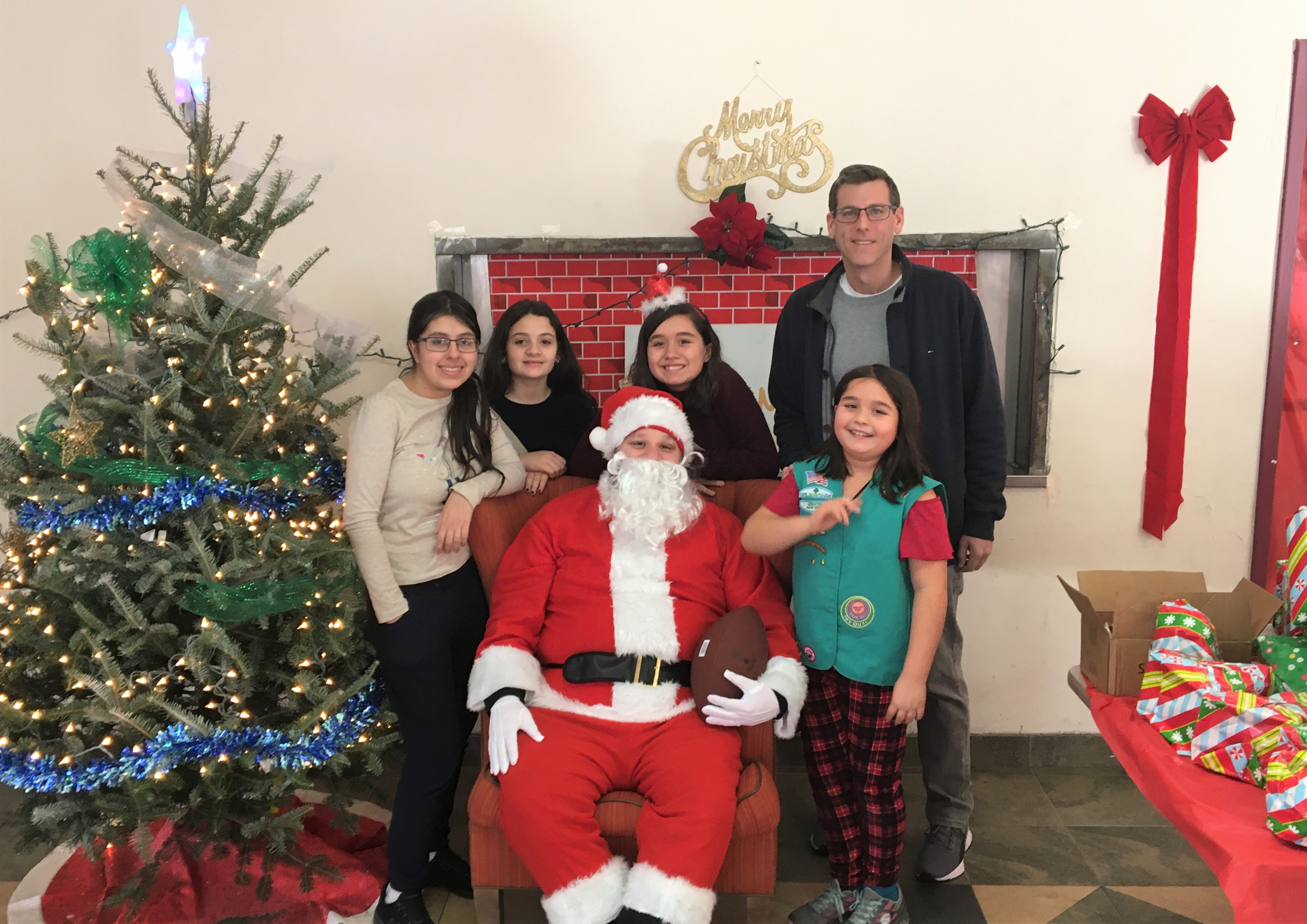 Assemblyman Braunstein is pictured with Santa and members of Girl Scout Troops 4076 and 4102 at the Belt Park Family Shelter on December 22, 2019.