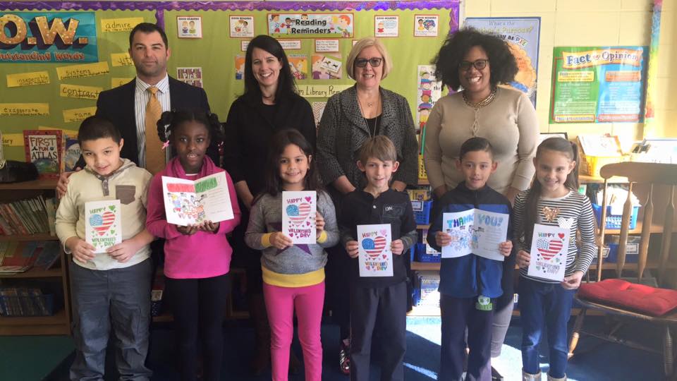 Assemblywoman Kimberly Jean-Pierre stands with elementary school students of the 11th Assembly District who made Valentine's cards for Veterans and Senior Citizens.