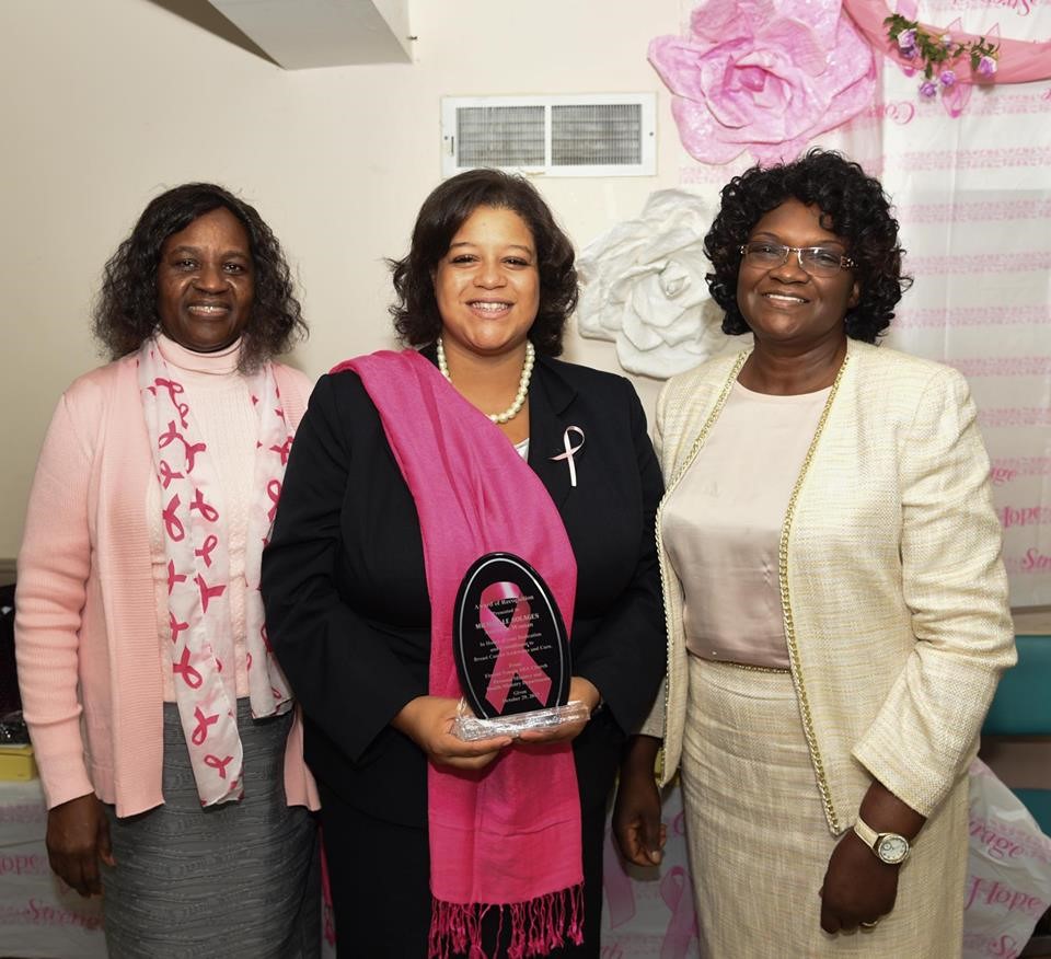Local advocates and community leaders award Assemblywoman Solages with a plaque acknowledging her commitment to combating breast cancer.