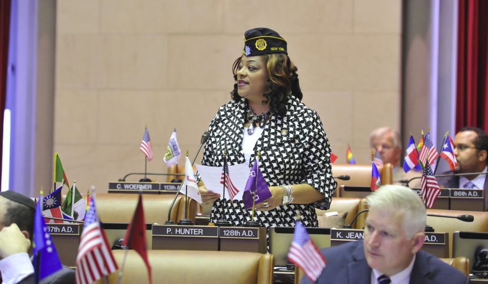 Assemblymember Hunter stands to introduce a group of women veterans from across the state in the assembly chamber.