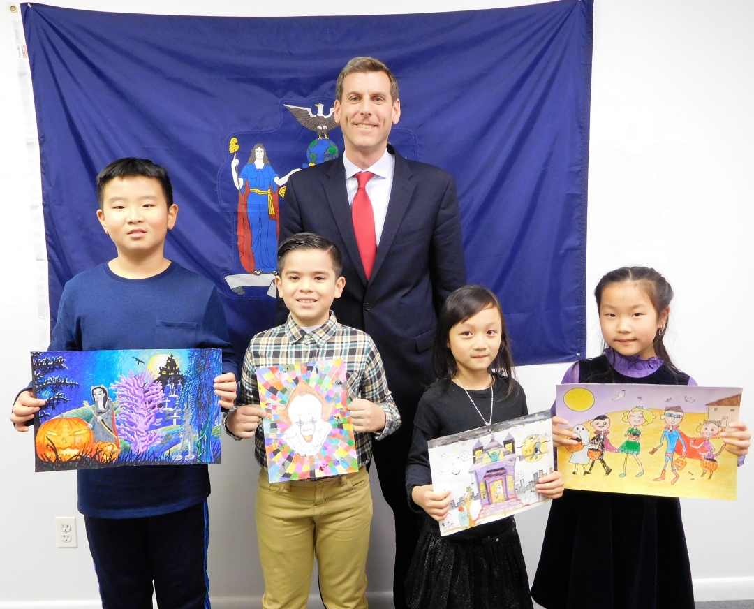 Pictured left to right with Assemblyman Braunstein: 5th Grade Grand Prize Winner Yuanpu Wang; 4th Grade Grand Prize Winner Juan Andres Montezuma; 3rd Grade Grand Prize Winner Melody Chen; and 2nd Grade Grand Prize Winner Lucia Jin.