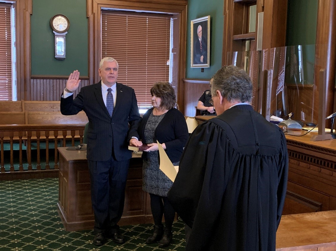 Assemblyman Joseph Angelino (R,C,I-Norwich) is sworn into his assembly office by NYS Supreme Court Justice Joseph McBride while the assemblyman’s wife, Kendall Saber, holds the family bible.